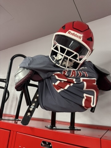 An East High School football helmet and jersey on display in the athletics corridor