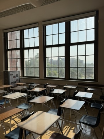 Student desks lined up beneath the tall windows of an East High School classroom