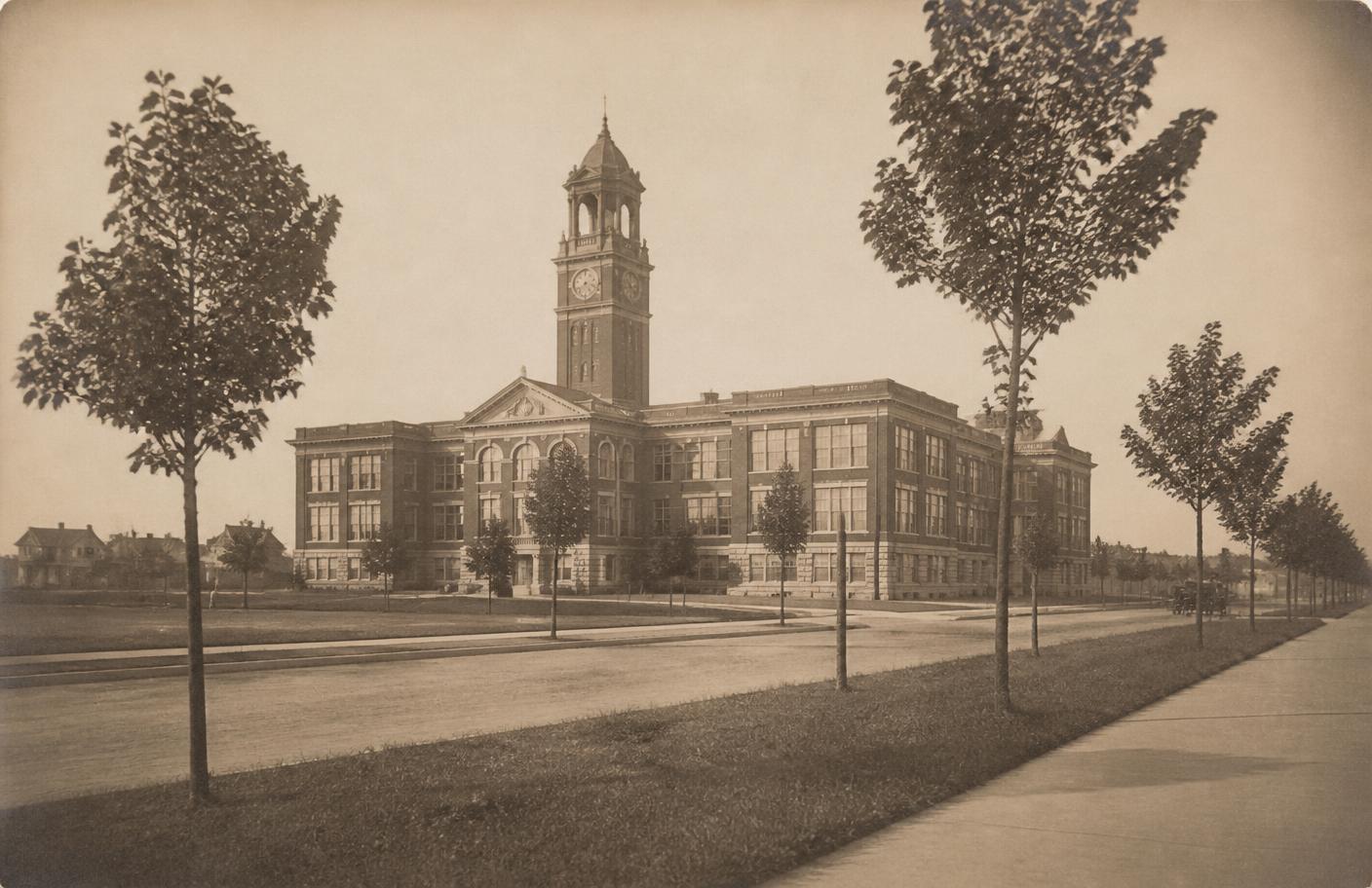 Sepia archival photograph of a 1920s high school building with a clock tower